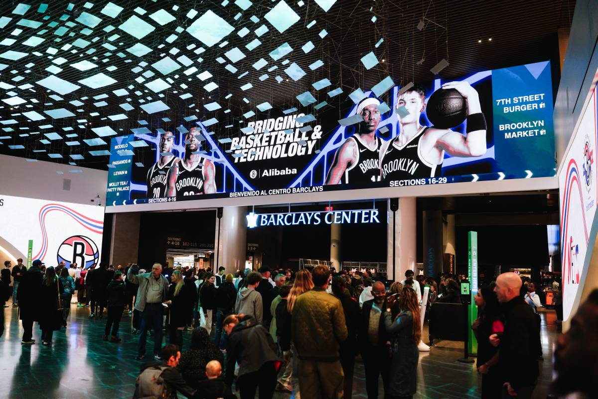 Crowds beneath Alibaba and Brooklyn Nets displays in Barclays Center concourse