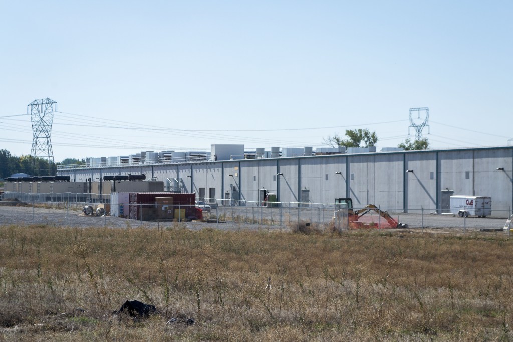 Amazon data center buildings with cooling infrastructure and power lines.