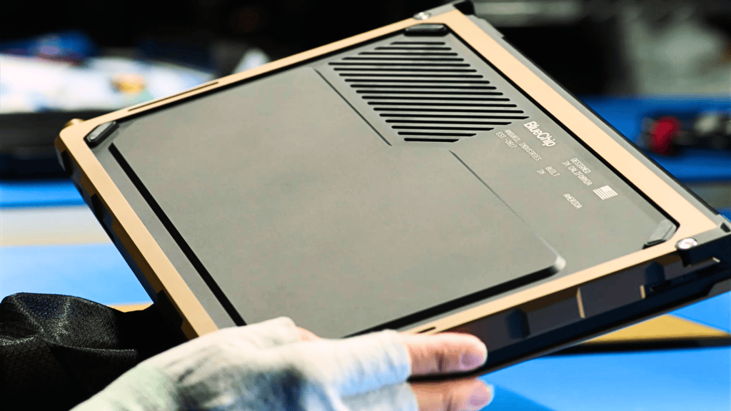 Underside of Anduril's BlueChip rugged laptop prototype with tan frame and ventilation
