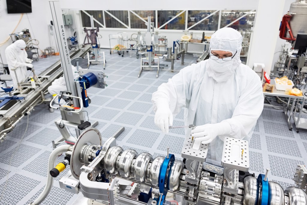 Semiconductor cleanroom technician working inside a high-purity manufacturing environment, representing U.S. silicon interposer production.