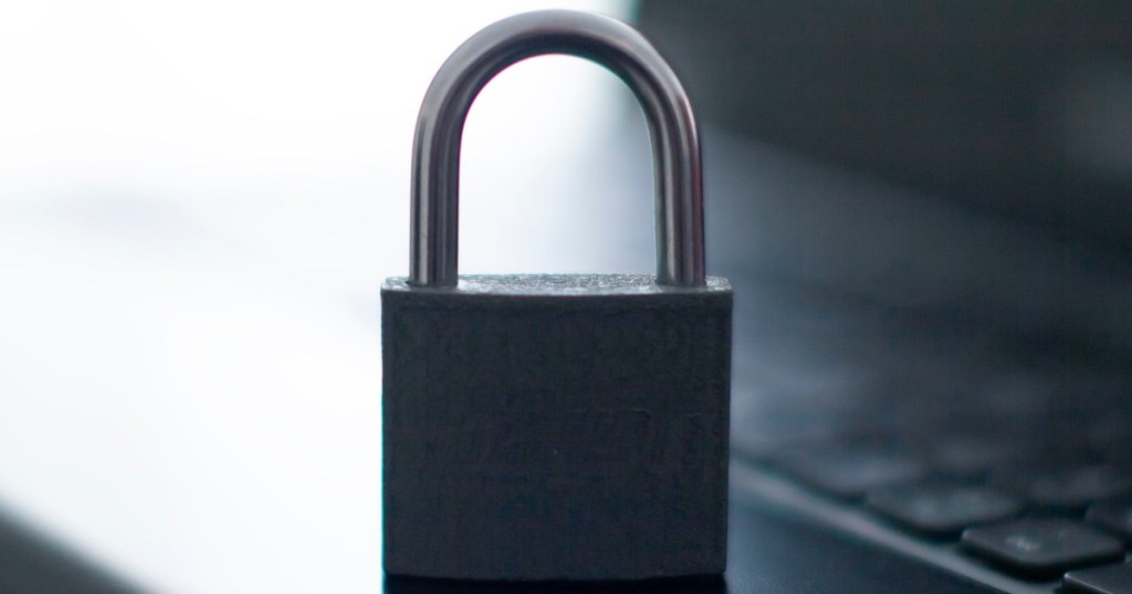 Closed metal padlock resting on a laptop keyboard, representing secure HTTPS and TLS web connections.