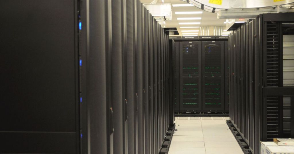 Rows of physical server racks representing the hardware that a hypervisor divides among virtual machines.