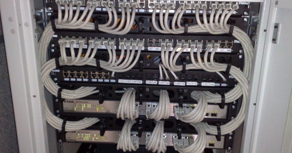 Rack-mounted Ethernet switches and patch panels representing high-speed AI data center networking.