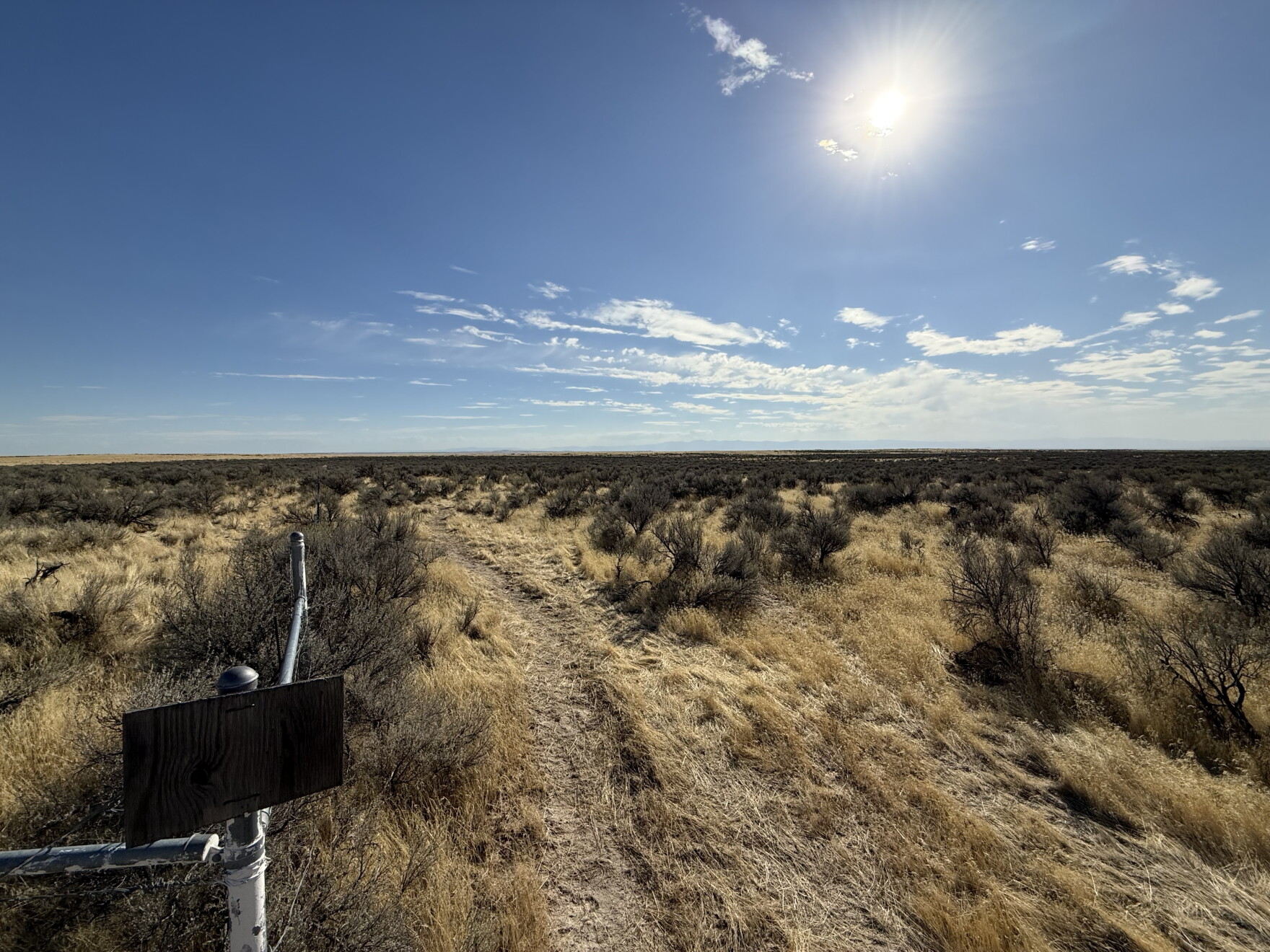 Sagebrush-covered public lands south of Boise with a dry pathway and blue sky