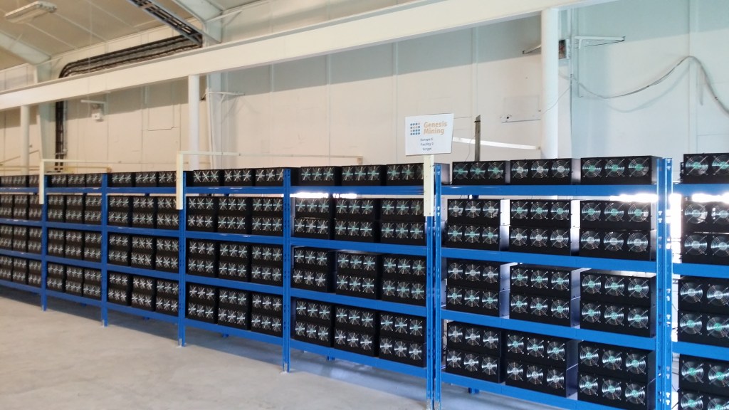 Rows of cryptocurrency mining computers operating inside a mining facility.