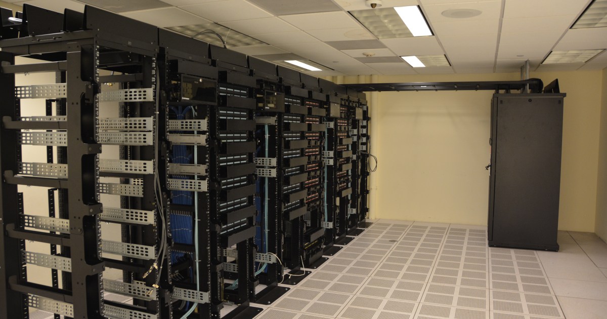 Server rack rows in a data center; editorial reference image