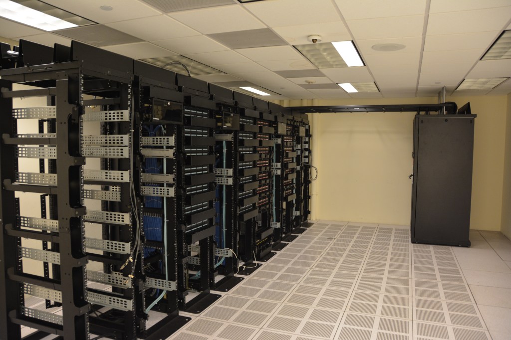 Rows of server racks inside a data center similar to the infrastructure used to host and cache internet content.