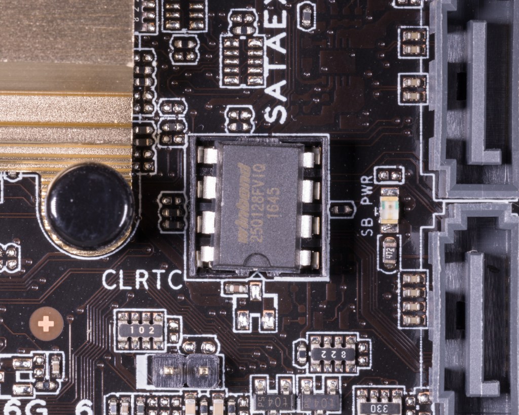 A DIP-8 BIOS flash chip mounted on a motherboard beside the standby power LED and clear RTC RAM header.