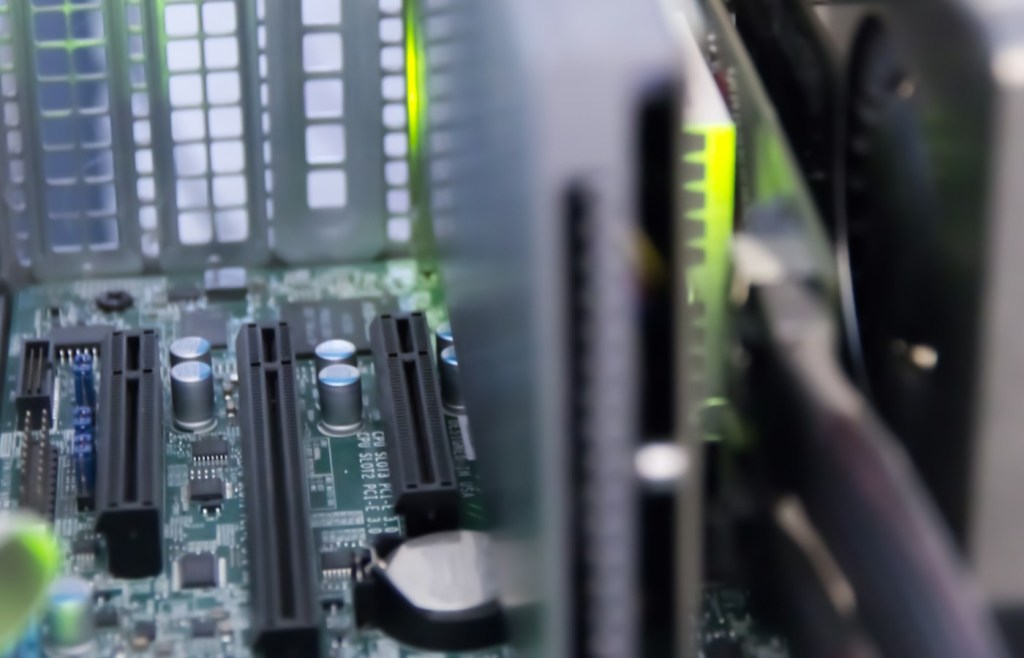 Server motherboard with PCIe slots and expansion cards representing devices that can transfer data with direct memory access.