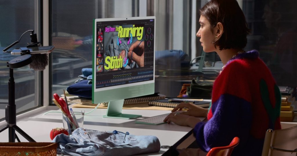 Adult professional editing video at a green M6 iMac in an Apple newsroom photograph