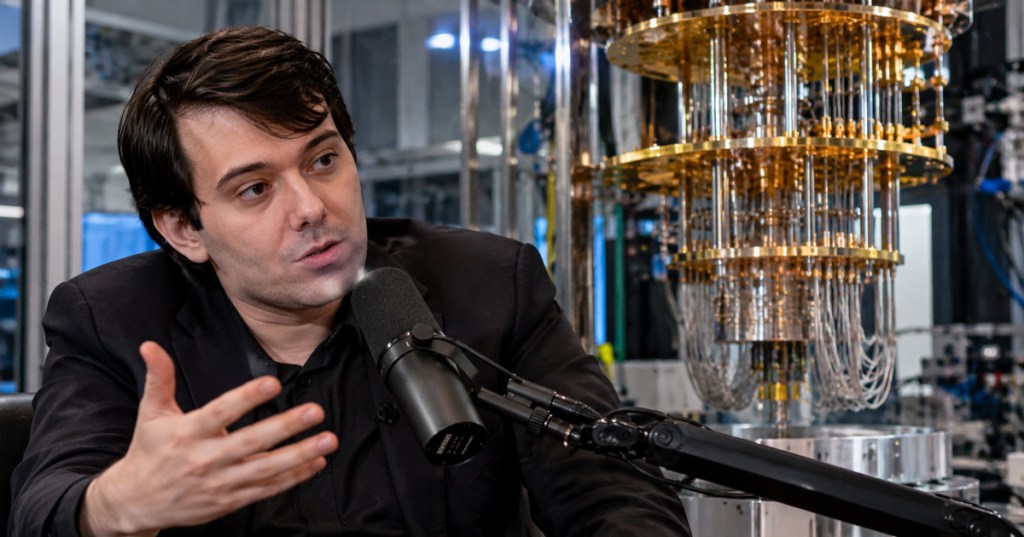 Martin Shkreli speaking into a podcast microphone beside quantum computing hardware in a realistic editorial image.