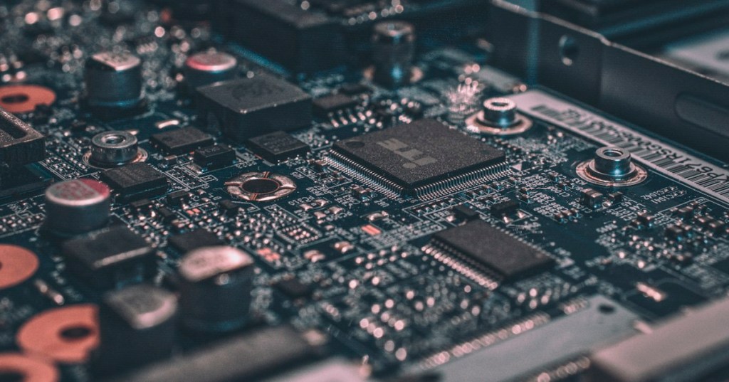 Realistic macro photograph of a computer circuit board representing memory-mapped I/O and hardware device registers.
