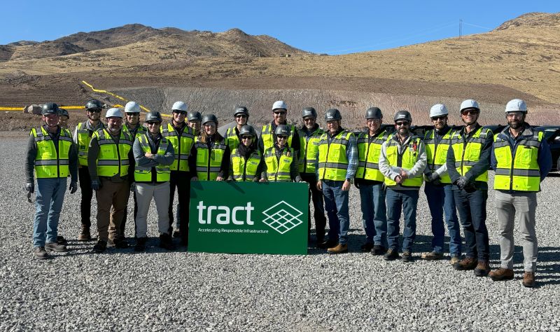 Tract development team in hard hats and high-visibility safety vests on a Nevada desert project tour