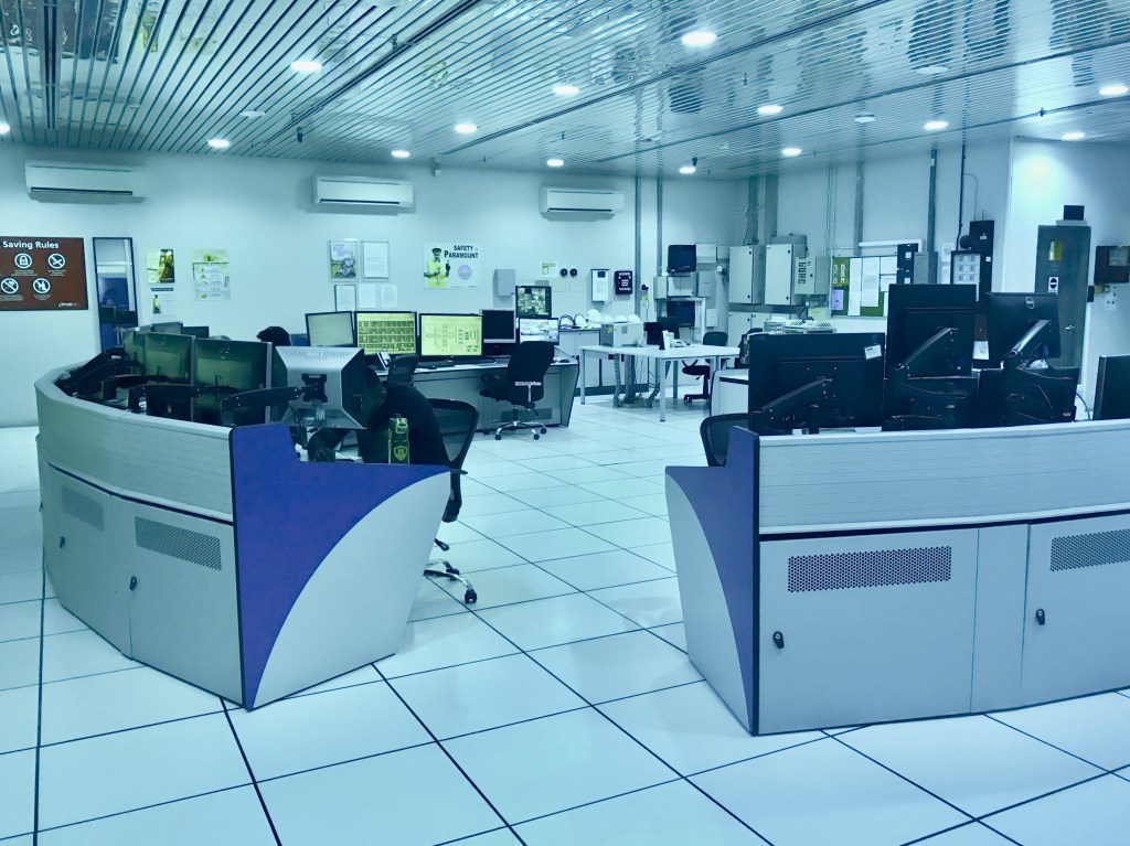 A SCADA control room at a NEWater water treatment plant with operators monitoring industrial process screens.