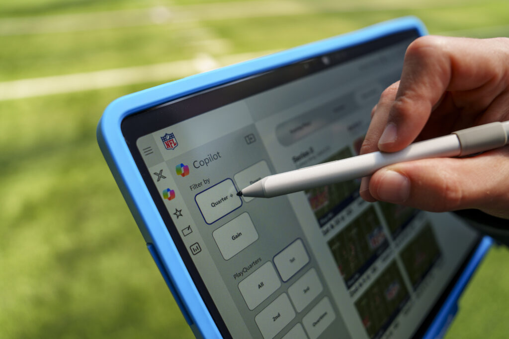 A Microsoft Surface Copilot device on an NFL sideline displaying the league's Sideline Viewing System and play filters.