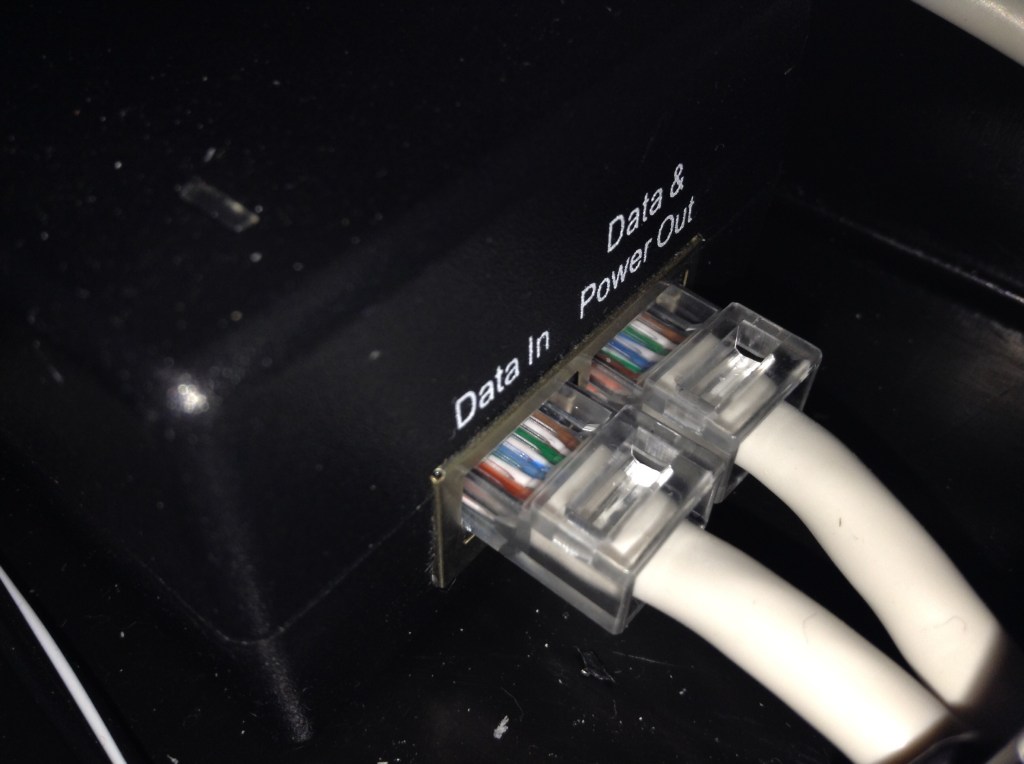 A Power over Ethernet injector with Ethernet ports, used to add power to an Ethernet cable for a compatible device.