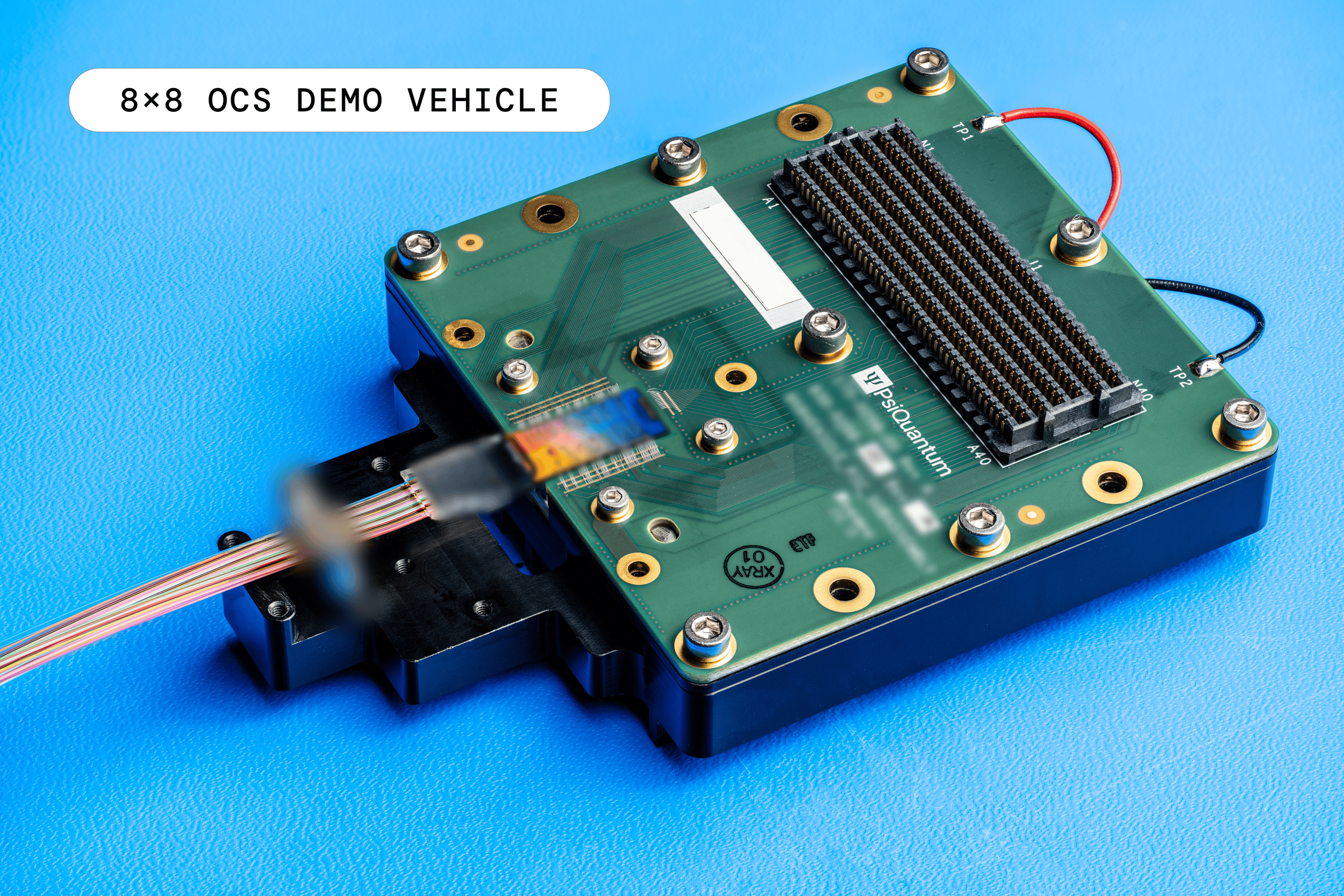 PsiQuantum 8 by 8 optical circuit switch test board with optical fiber cable and electrical connector on blue background