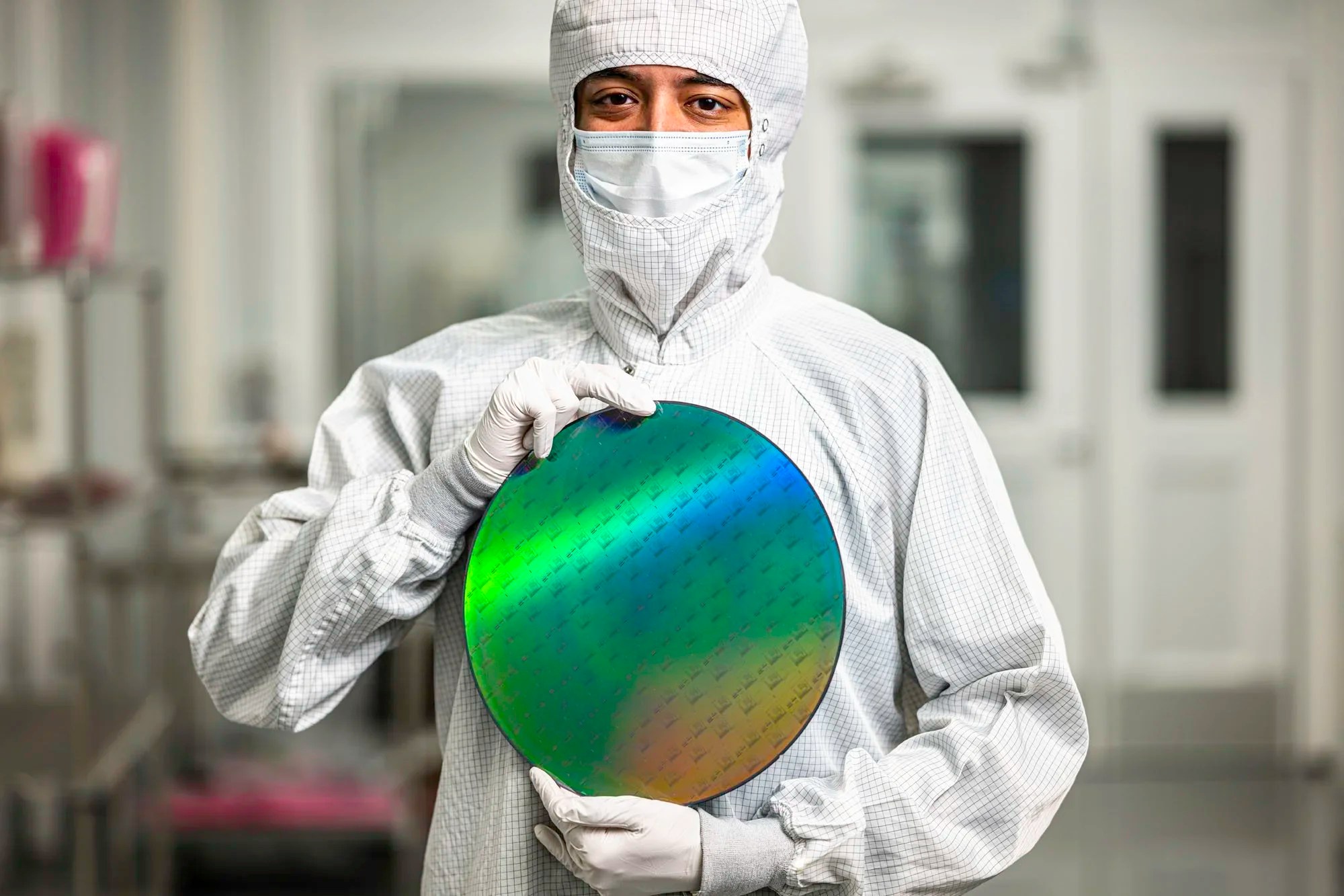 PsiQuantum cleanroom engineer holding a multicolored silicon photonics wafer