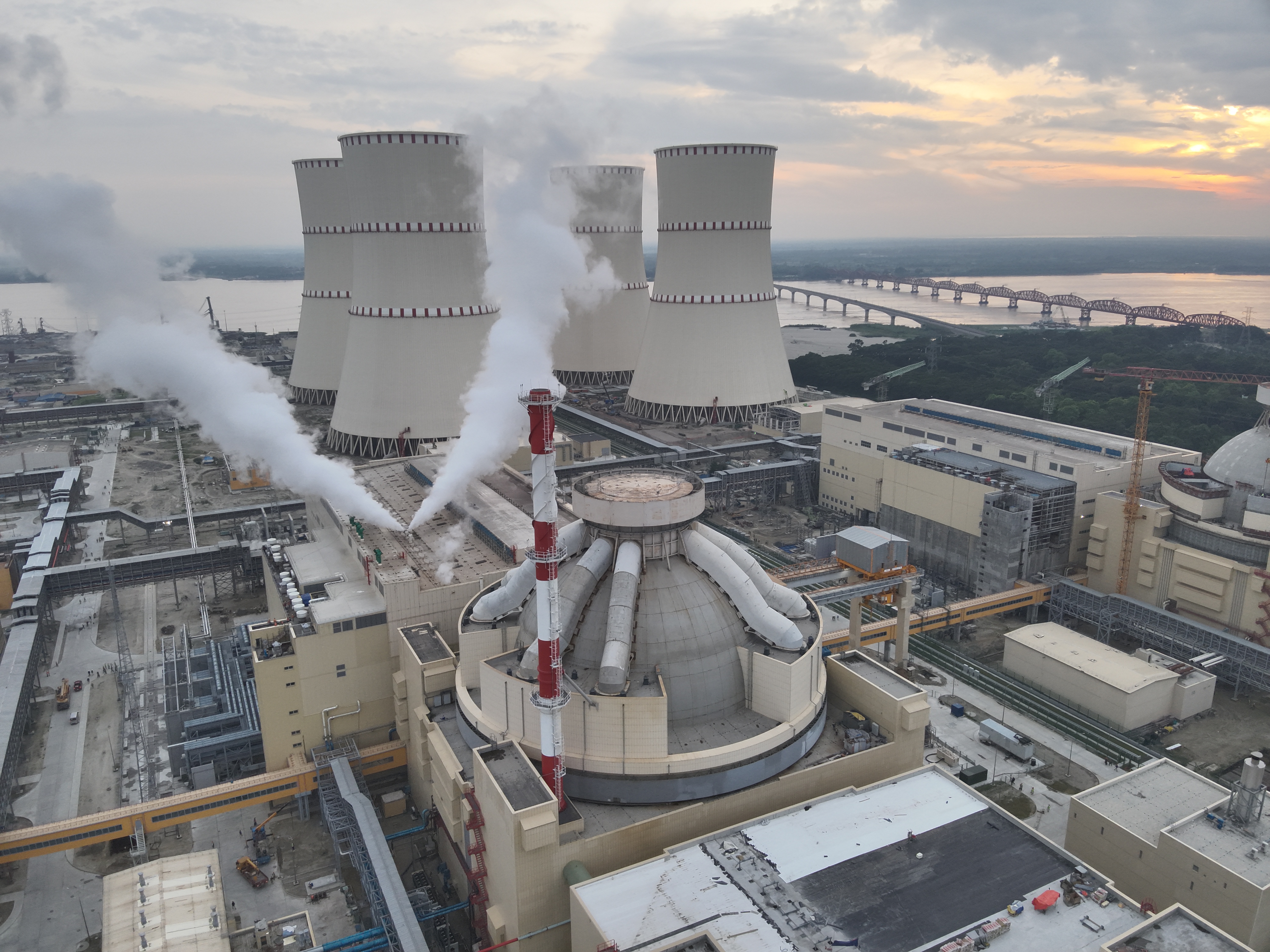 Rooppur nuclear power station during a 2025 steam-pipeline commissioning test, with cooling towers and steam plumes