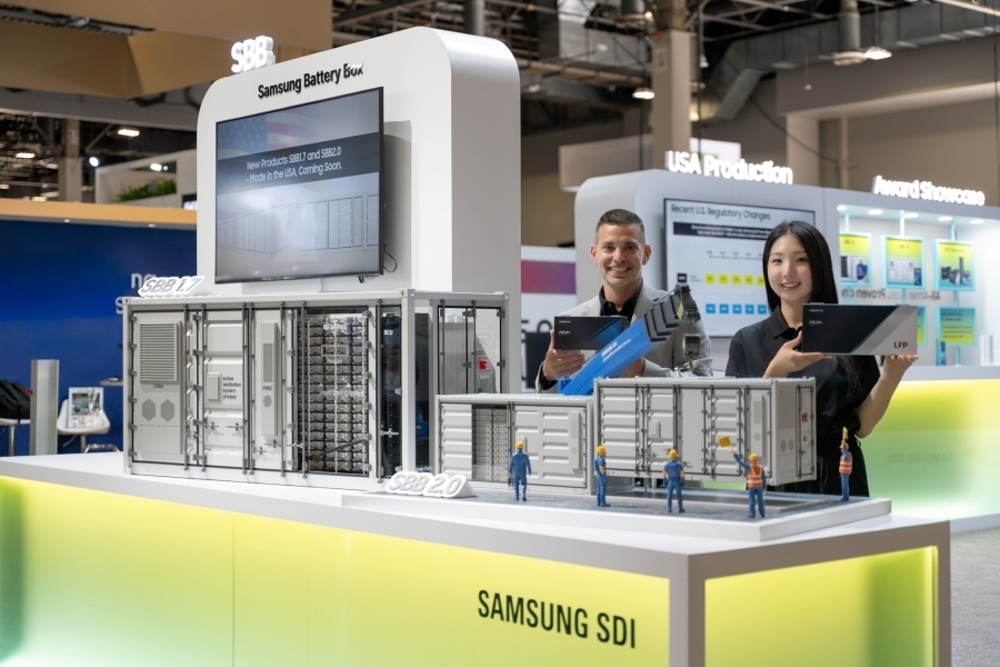 Samsung SDI representatives standing behind scale models of SBB energy storage containers at RE+ 2025