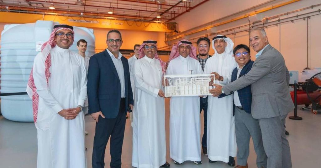 Saudi energy and research representatives standing beside a direct lithium extraction pilot model