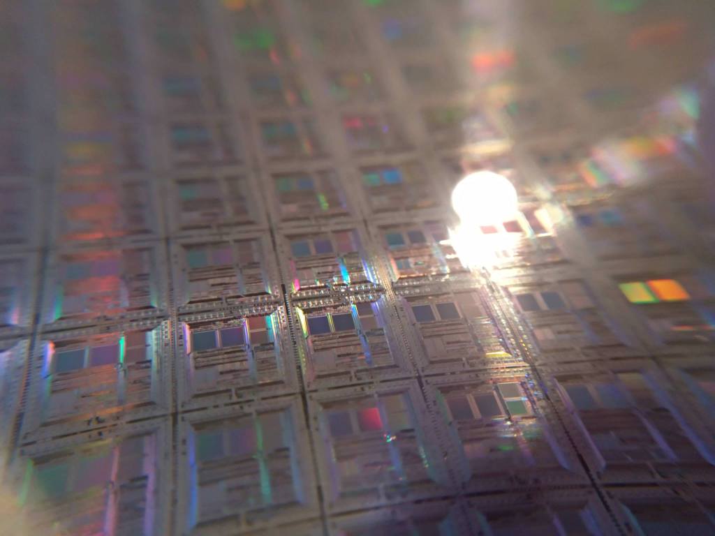 Repeating patterned dies on a silicon wafer, shown as general fabrication context.