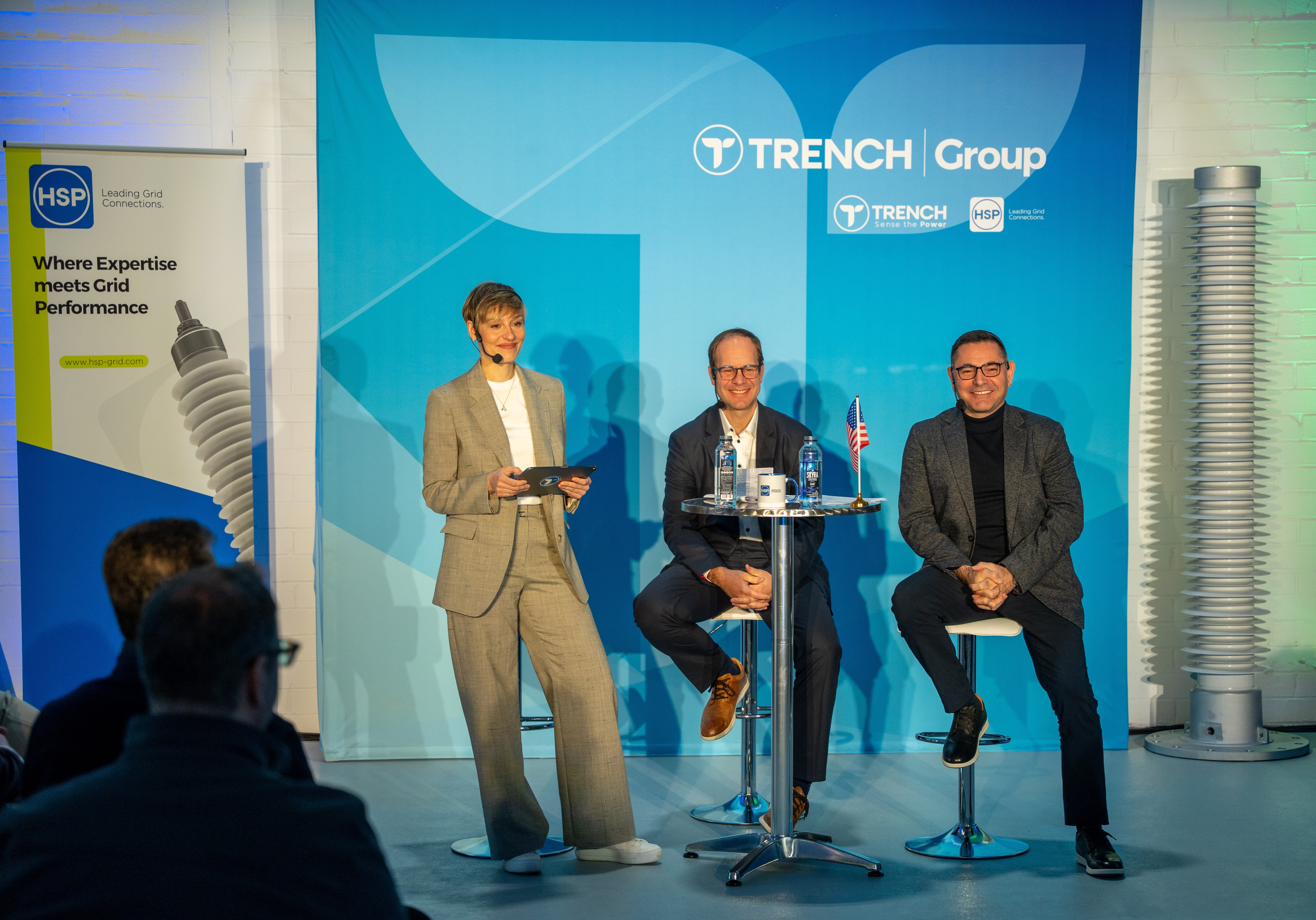 Trench Group executives discuss U.S. manufacturing at a February 2026 event beside a large insulating bushing