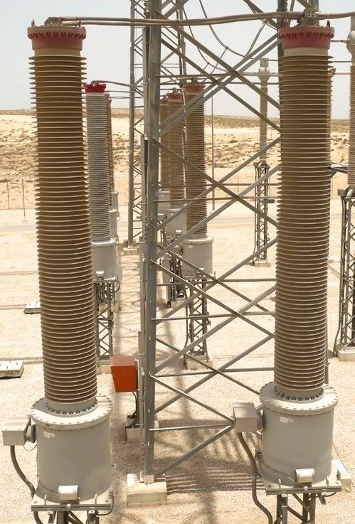 Trench Group ribbed high-voltage instrument transformers installed in an outdoor electrical substation