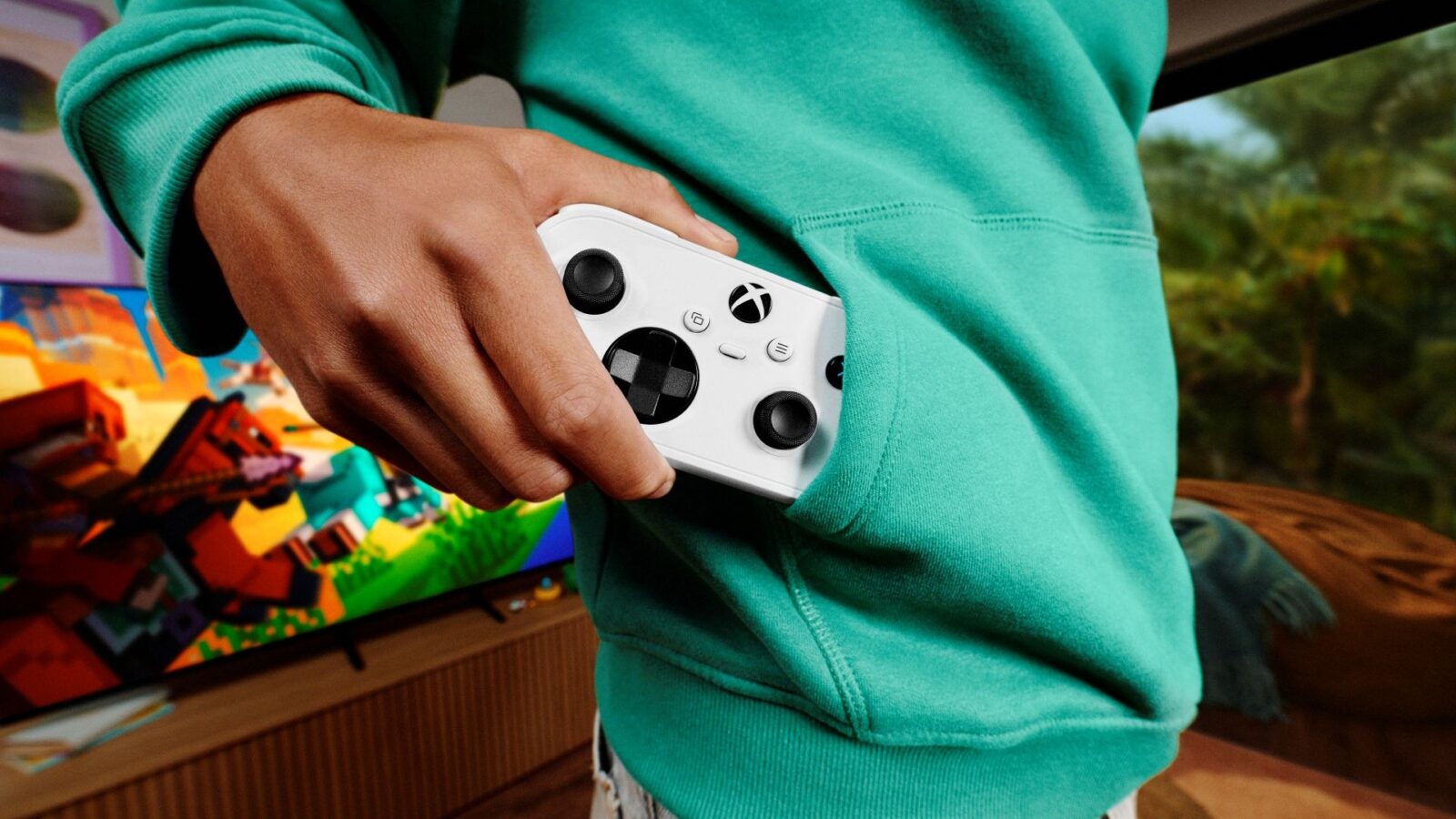 Official Xbox launch image showing the compact white Xbox Nano Controller being slipped into a hoodie pocket.